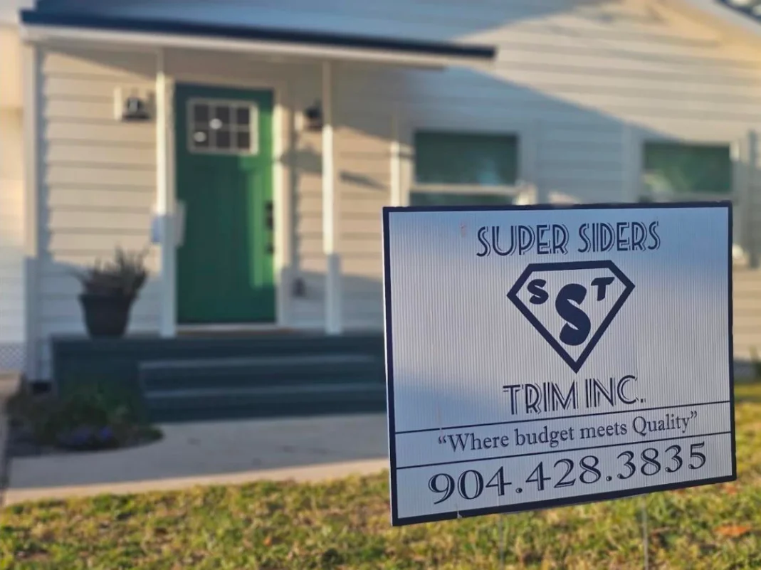 Professional exterior installation crew with tools and materials staged for siding and trim work on a residential home.