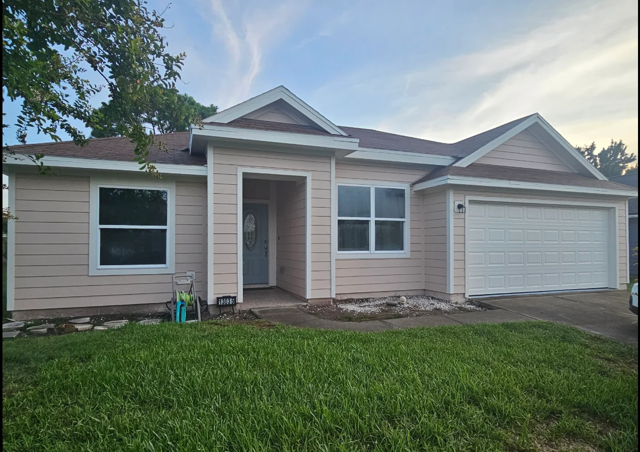 Single-story home with pink-beige horizontal lap siding, white corner and window trim, and gabled entry portico