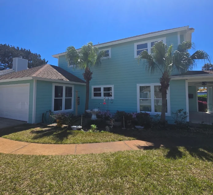Two-story home with teal horizontal lap siding, white window trim, and white fascia