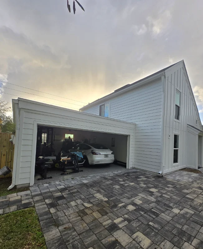 White lap and board-and-batten siding on two-story home with white trim and attached carport